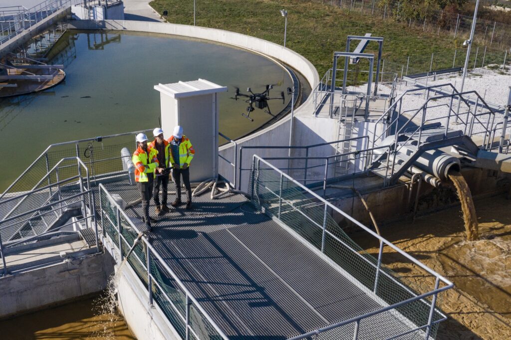 Engineers assesing waste treatment plant with drone copy scaled