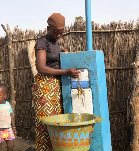 Woman operates card-based water services Wellingaraba, Gambia