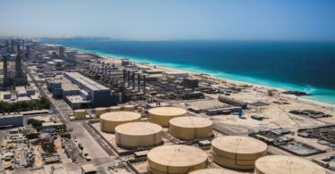 Aerial view of a desalination plant with storage tanks near the coast