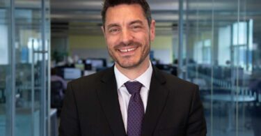 Portrait of James Jesic, incoming CEO of Severn Trent, standing in an office environment.
