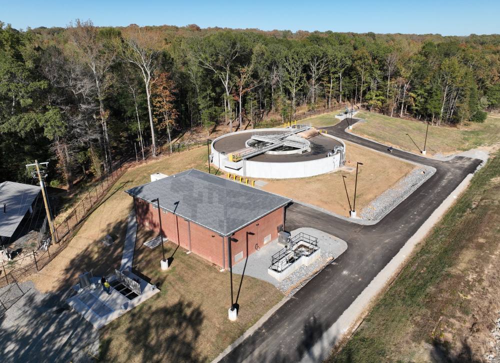 Aerial view of the new Gravel Ridge mechanical wastewater treatment plant, showing the circular aeration and clarification basin and adjacent operations building.