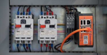 Samotics SAM4 data acquisition device installed inside a motor control cabinet with connected wiring.