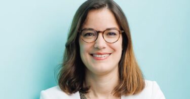 Portrait of Morgane Pigeaux, newly appointed Managing Director of HydroThane, smiling and wearing glasses and a white blazer.