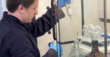 Laboratory technician conducting PFAS testing on water samples using analytical equipment