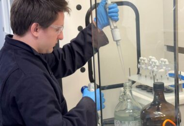 Laboratory technician conducting PFAS testing on water samples using analytical equipment