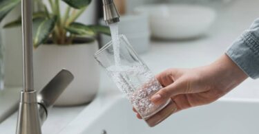 Water Saving Week tap water image showing clean drinking water flowing into glass from kitchen tap