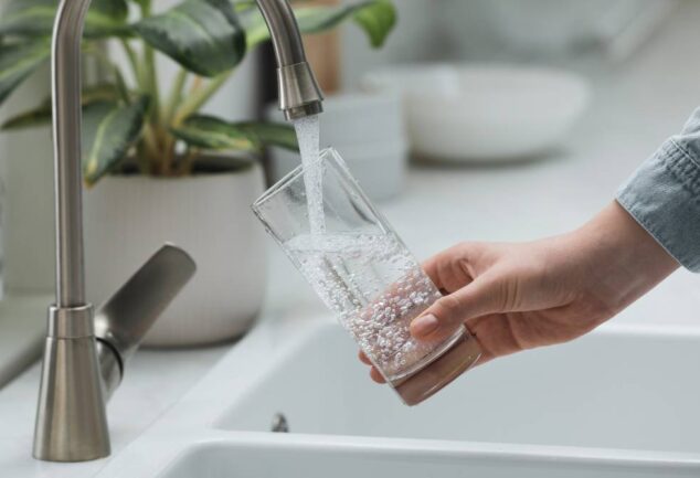 Water Saving Week tap water image showing clean drinking water flowing into glass from kitchen tap