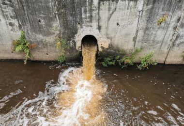 Storm overflow discharge releasing untreated wastewater into a river during a sewage pollution event.