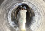 Technicians installing carbon fibre reinforced polymer liner inside Montr&eacute;al water transmission main rehabilitation project