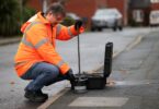Ovarro technician using acoustic leak detection equipment to identify water network leakage in an urban street environment