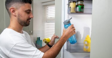 A bottle of chilled drinking water in a fridge, illustrating an appeal to use water for essential purposes during a heatwave