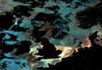 Ocean-colour satellite image of the UK and surrounding north-east Atlantic waters, showing phytoplankton, sediment and dissolved organic matter patterns captured by Copernicus Sentinel-3.