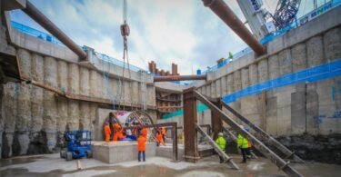 Construction workers in a large water infrastructure excavation with tunnelling equipment