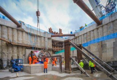 Construction workers in a large water infrastructure excavation with tunnelling equipment