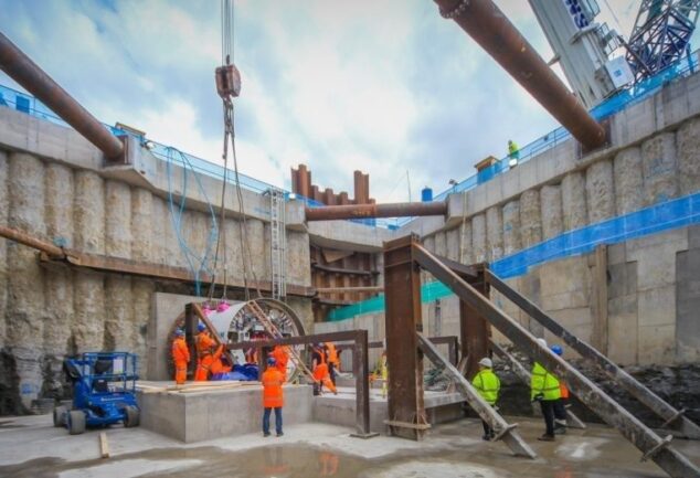 Construction workers in a large water infrastructure excavation with tunnelling equipment
