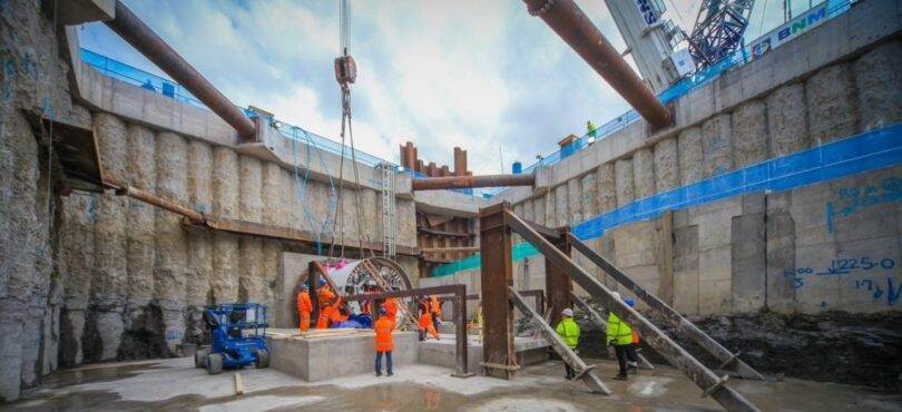 Construction workers in a large water infrastructure excavation with tunnelling equipment