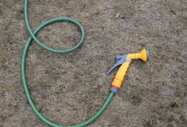Hosepipe lying on dry grass during hot weather