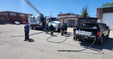 Wastewater operators attending an onsite sewer nozzle demonstration with jetting equipment