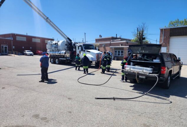 Wastewater operators attending an onsite sewer nozzle demonstration with jetting equipment