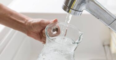 Tap water running into a glass jug during hot weather