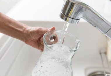 Tap water running into a glass jug during hot weather