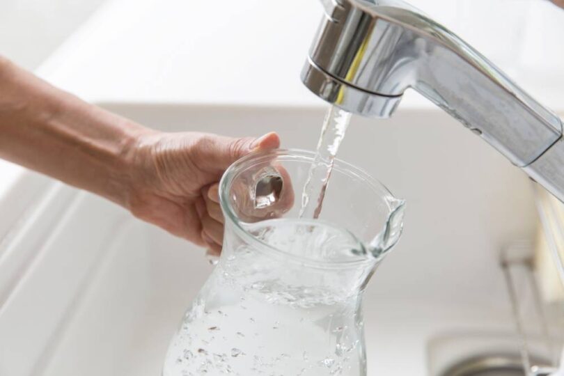 Tap water running into a glass jug during hot weather