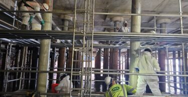 Workers applying protective coating to wharf piles during the Nashville Wharf rehabilitation project