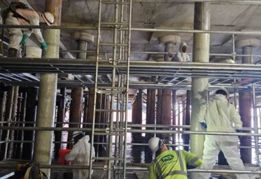 Workers applying protective coating to wharf piles during the Nashville Wharf rehabilitation project