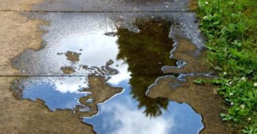 Water leakage reduction illustrated by a leaking water pipe creating a puddle on a patio