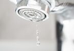 Close-up of a tap aerator with water droplets
