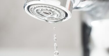 Close-up of a tap aerator with water droplets
