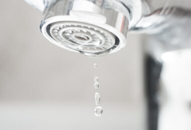 Close-up of a tap aerator with water droplets