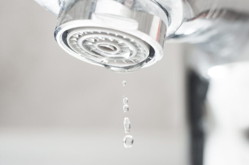 Close-up of a tap aerator with water droplets