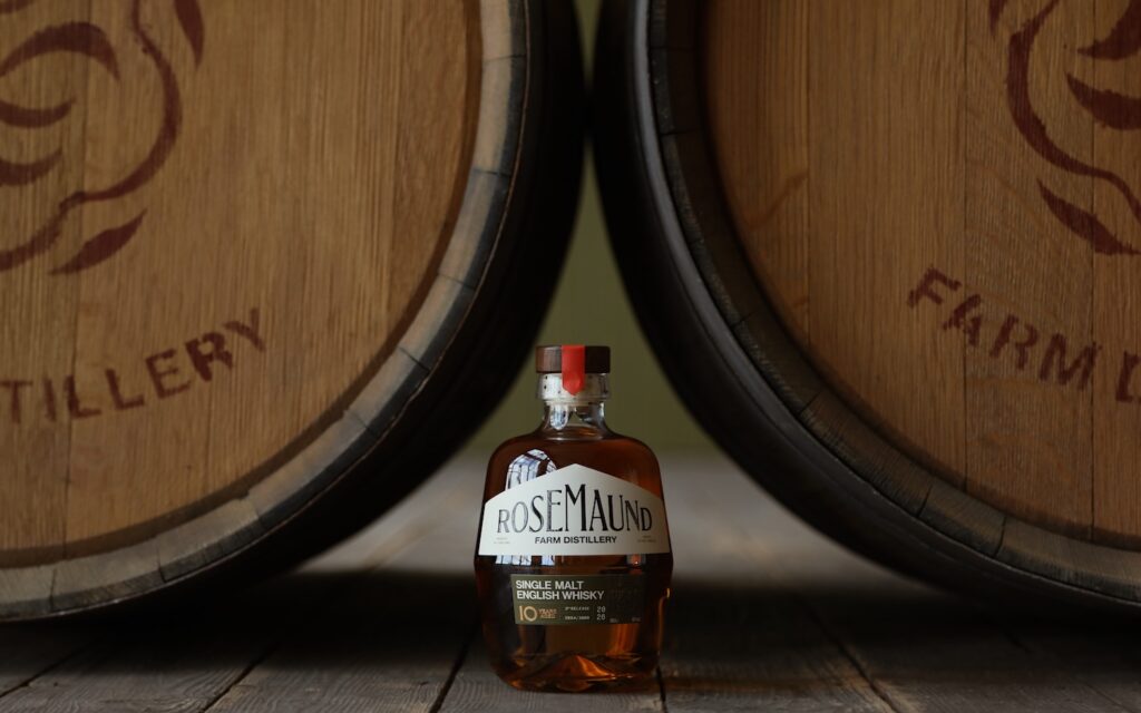 Rosemaund Farm Distillery single malt English whisky bottle between wooden casks