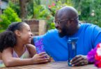 Adult and child with reusable water bottles in a garden