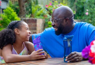 Adult and child with reusable water bottles in a garden