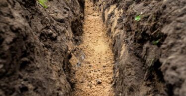 Freshly excavated trench prepared for underground utility installation before pipeline works