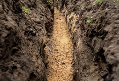Freshly excavated trench prepared for underground utility installation before pipeline works