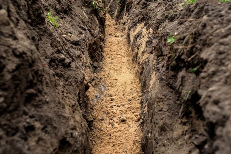 Freshly excavated trench prepared for underground utility installation before pipeline works