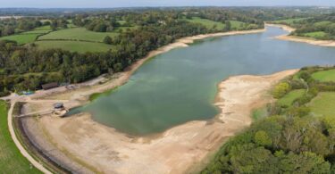 Aerial view of low water levels and exposed banks at Ardingly Reservoir in Sussex