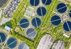 Aerial view of a sewage treatment plant with circular clarifier tanks and water basins