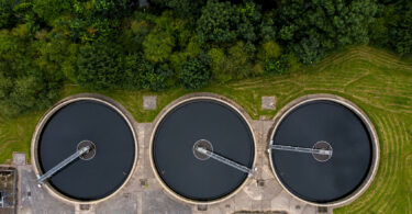 Aerial view of a sewage and wastewater treatment works in the UK, showing tanks and site infrastructure.
