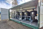 Flocell XFM modular filtration system featuring four filtration vessels, pipework and valves housed inside an open-sided container.
