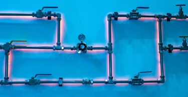 Gas pipes in front of a wall background, shown in a stock photo.