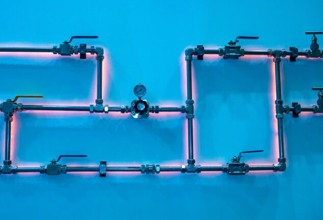 Gas pipes in front of a wall background, shown in a stock photo.