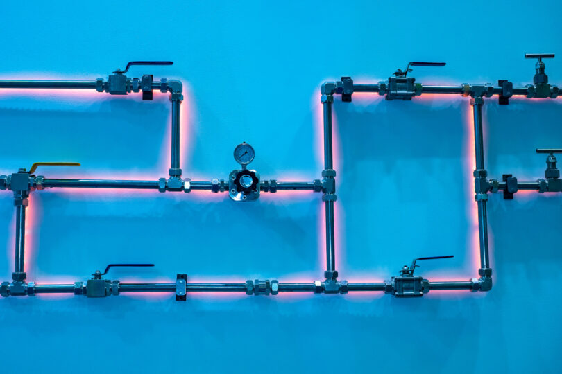 Gas pipes in front of a wall background, shown in a stock photo.