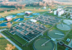 Aerial view of a wastewater treatment plant, showing its layout of structures and basins from above.