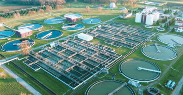 Aerial view of a wastewater treatment plant, showing its layout of structures and basins from above.