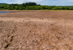 Baked, cracked, dry soil at a near-empty reservoir during a heatwave and drought.