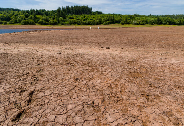 Baked, cracked, dry soil at a near-empty reservoir during a heatwave and drought.